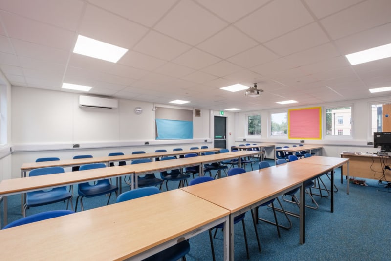Interior of a modular classroom showing rows of desks.