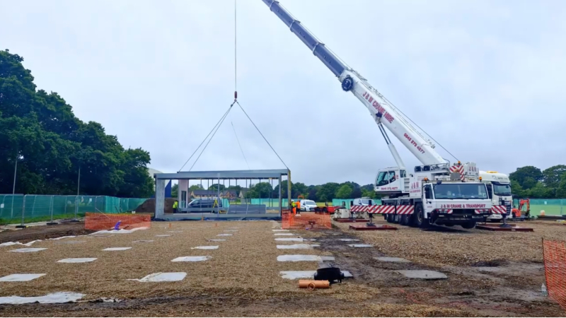 crane moving modular building into location